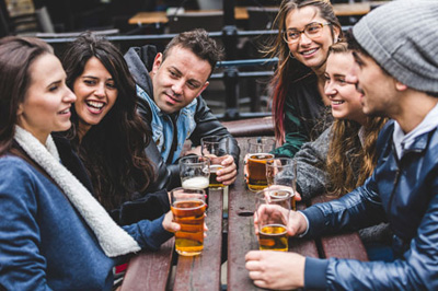 Eine Gruppe von Sprachreisenden trinkt an einem Tisch ein Guinness Bier